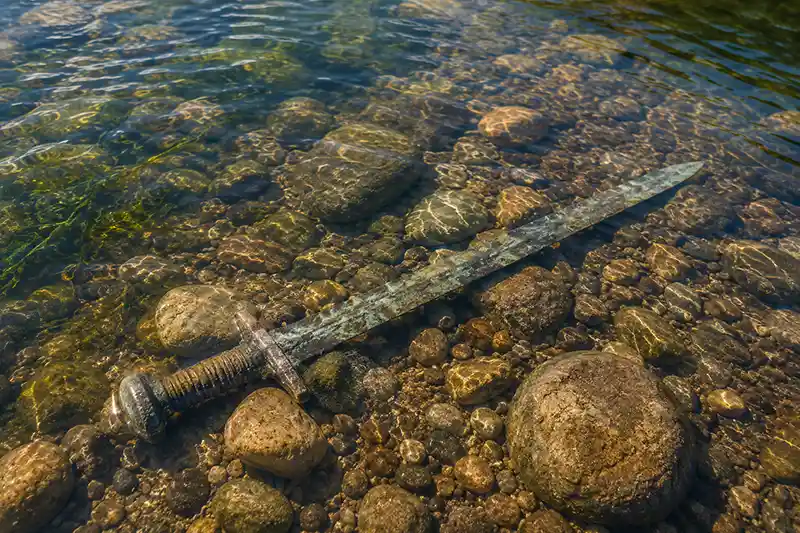 Ancient sword resting beneath clear river water