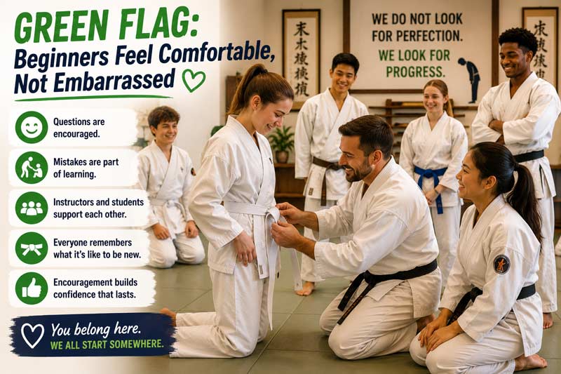 Martial arts instructor helping a nervous beginner tie a belt in a welcoming dojo while supportive students encourage them.
