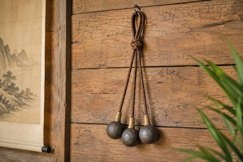 Traditional three-ball bolas hanging on a wooden wall