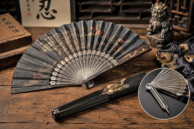 Decorative fighting fan with reinforced metal ribs displayed on a rustic wooden table in a historical martial arts setting, representing a hidden everyday object with an unexpected purpose