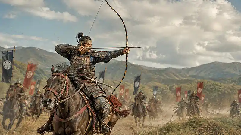 Mounted samurai archer drawing a towering yumi bow while charging across a battlefield in feudal Japan.