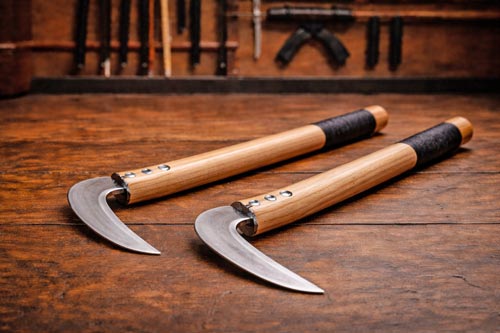 Traditional wooden kama on a dojo floor